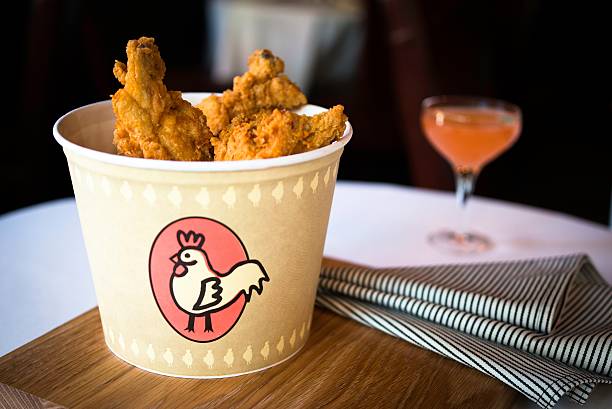 bucket of fried chicken on restaurant table - junk food stock pictures, royalty-free photos & images