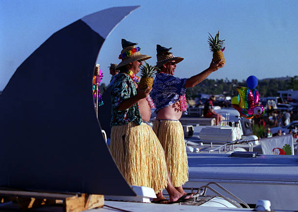 Buffett.hula.1010.ASIRVINEParrot heads Mike Berg, left, and Steve Mutt, both of San Diego, stand on an RV during a party in the parking lot...