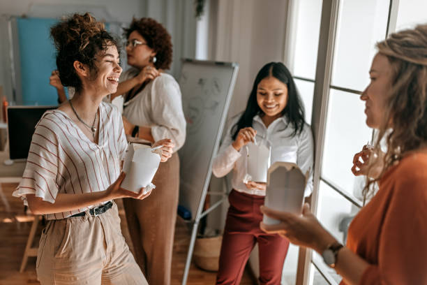 business colleagues having fun during lunch break at office - junk food stock pictures, royalty-free photos & images