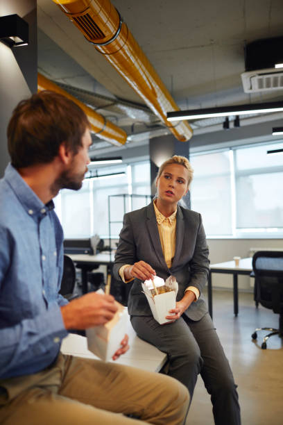 business people eating in their office - junk food stock pictures, royalty-free photos & images