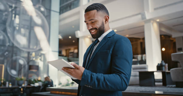 businessman, digital tablet or strategy planning in hotel conference lobby or airport travel lounge. happy smile, corporate worker or technology app to budget company finance or schedule target goals - travel stock pictures, 