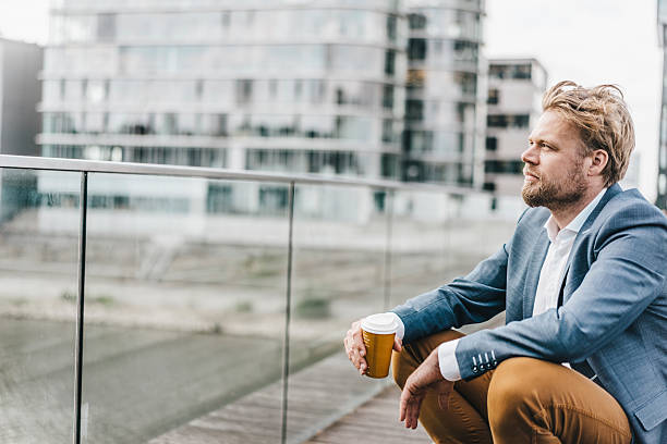 businessman sitting on bridge having coffee break - junk food stock pictures, royalty-free photos & images