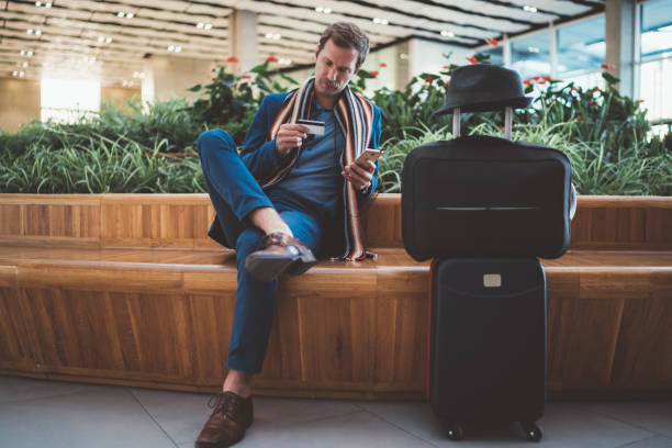 businessman using online banking at the airport - travel stock pictures, royalty-free photos & images