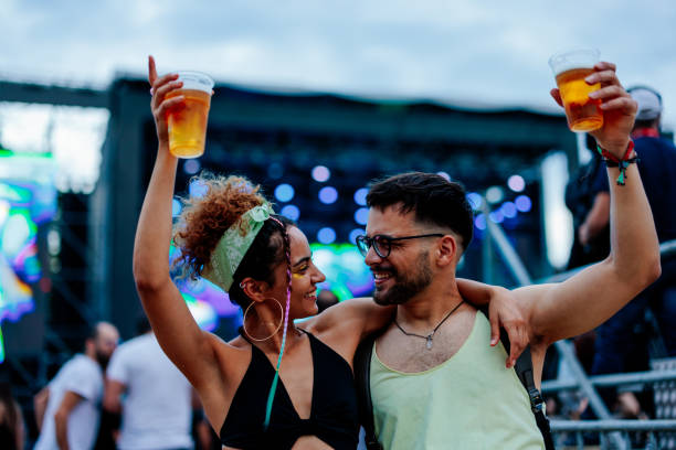 câlin de couple avec une bière à la main au concert - concert photos et images de collection