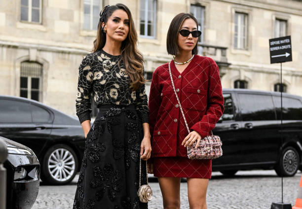 Camila Coelho and Aimee Song are seen wearing Chanel black and red outfits with Chanel bags outside the Chanel show during the Womenswear...