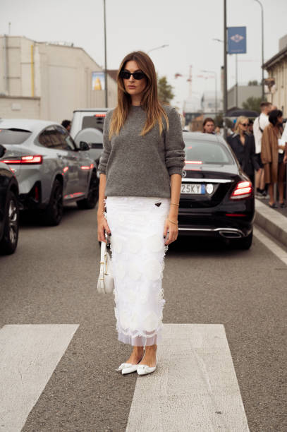 Camille Charriere wears a white top, laced skirt, pointed heels, and bag outside Prada during the Milan Fashion Week - Womenswear Spring/Summer 2024...