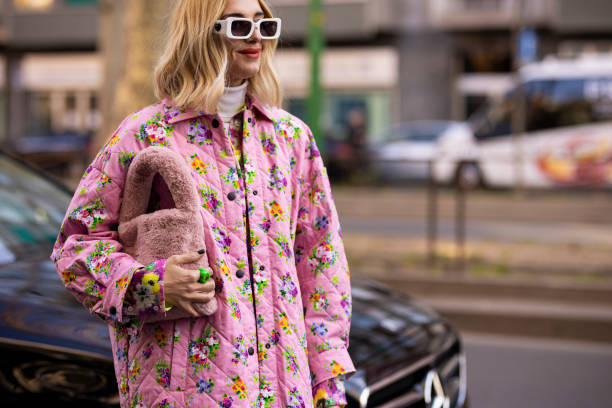 Candela Pelizza poses ahead of the MSGM fashion show wearing a pink floral printed sequins shirt, pink floral printed pants and jacket, pink fur bag...