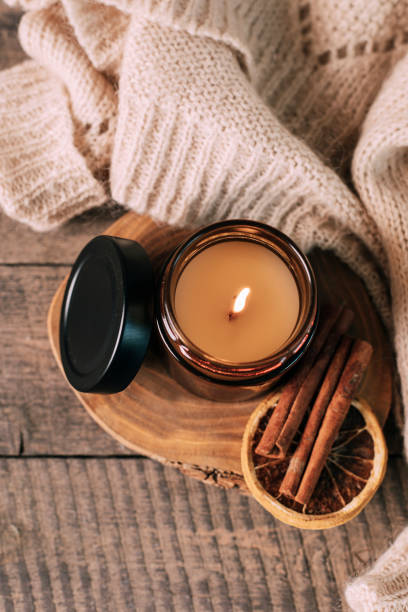 candle in small amber glass jar with wooden wick on wooden stand on background. top view - home decoration stock pictures, royalty-free photos & images
