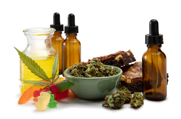 cannabis oils and bud in a small bowl surrounded by sweet edibles - food stock pictures, royalty-free photos & images