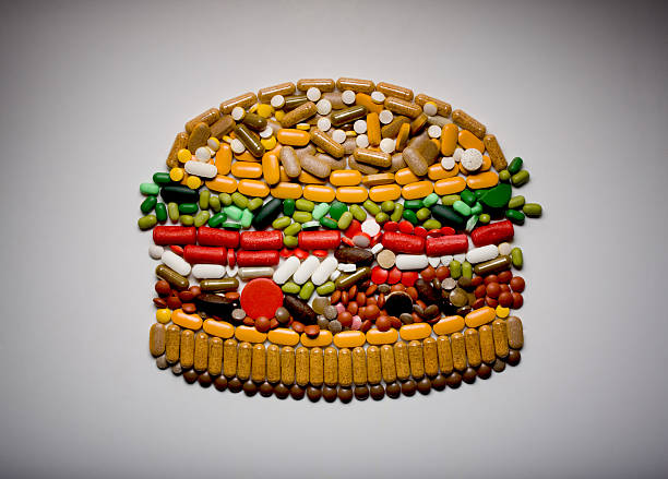 capsules and pills in shape of hamburger - junk food stock pictures, royalty-free photos & images