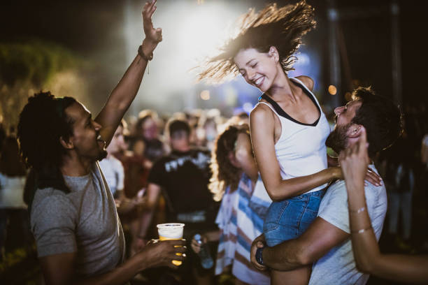 carefree friends having fun on music festival by night. - concert stock pictures, royalty-free photos & images