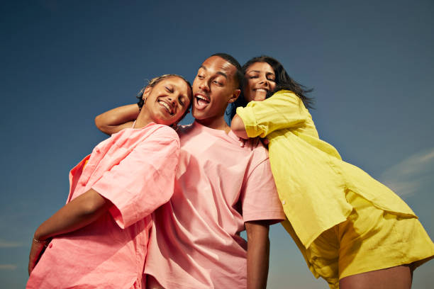 carefree friends standing against sky - fashion stock pictures, royalty-free photos & images
