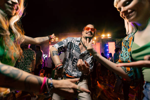 carefree man dancing with his friends on music concert by night. - concert stock pictures, royalty-free photos & images