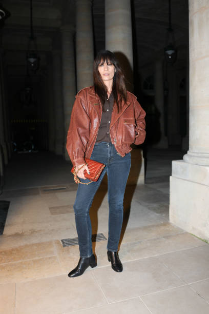 Caroline de Maigret wears dark brown buttoned up long sleeve shirt, dark brown oversized leather jacket, dark brown quilted leather bag, black skinny...