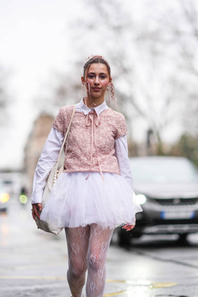 Caroline Takrarit wears a white shirt, a pastel pale pink floral embroidery t-shirt, a white tulle gathered / pleated mini skirt, floral embroidery...