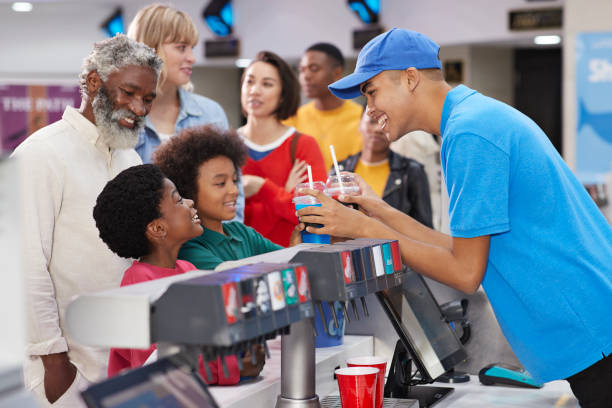 cashier giving drinks to customers at concession stand - junk food stock pictures, royalty-free photos & images