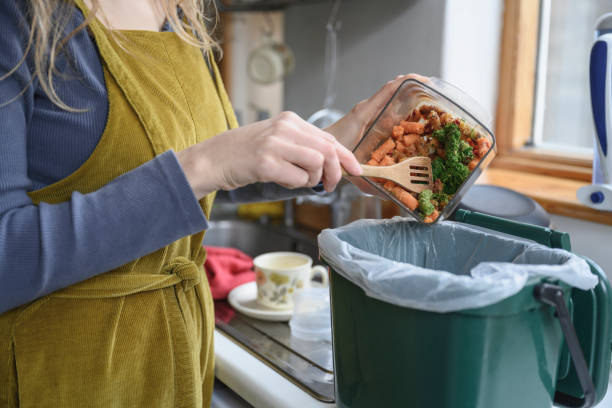 caucasian woman adding vegetable remains to compost bin - food stock pictures, royalty-free photos & images