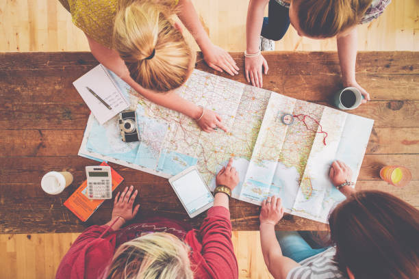 caucasian women planning trip with map on wooden table - travel stock pictures, royalty-free photos & images