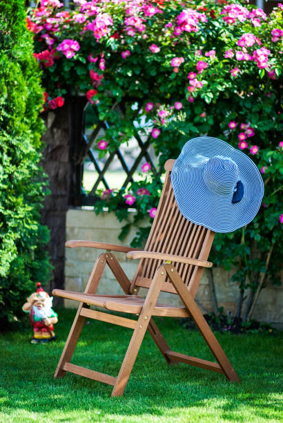 chaise lounge chair at the garden with a hat on it - garden decoration stock pictures, royalty-free photos & images