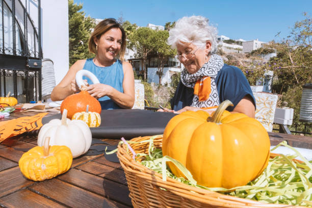 chatting and smiling women preparing halloween decoration - garden decoration stock pictures, royalty-free photos & images