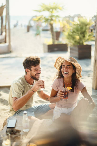 cheerful couple having fun in a beach café. - travel stock pictures, royalty-free photos & images