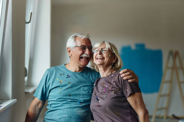 cheerful embraced senior couple during home renovation process. - home decoration stock pictures, royalty-free photos & images