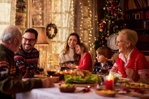 cheerful extended family talking during christmas dinner at home. - food stock pictures, royalty-free photos & images