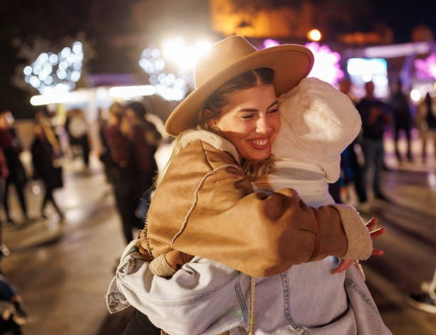 cheerful female friends hugging in amusement park in the evening - concert stock pictures, royalty-free photos & images