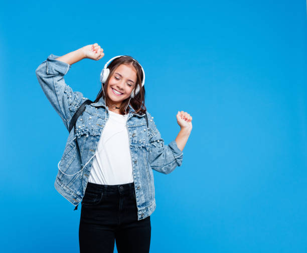 cheerful female high school student listening to music - fashion stock pictures, royalty-free photos & images