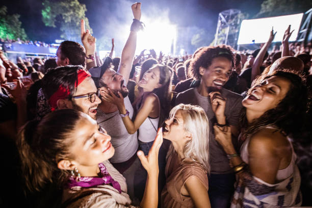 cheerful friends dancing and signing on music festival by night. - concert stock pictures, royalty-free photos & images