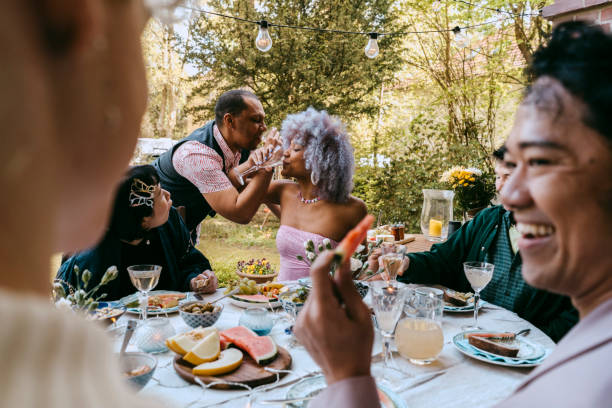 cheerful friends of lgbtq community enjoying during party in back yard - garden decoration photos et images de collection