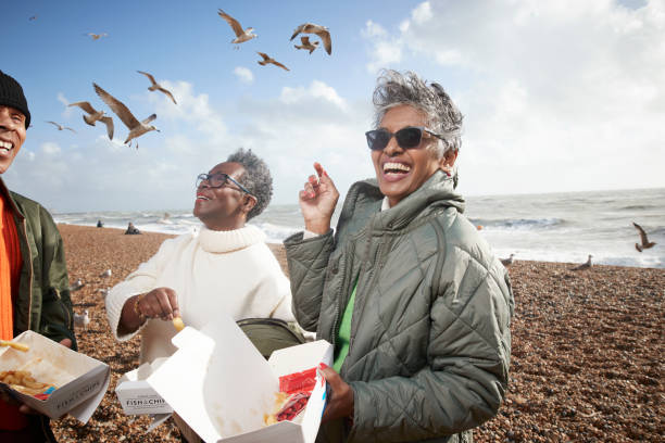 cheerful male and female friends having french fries - travel stock pictures, royalty-free photos & images