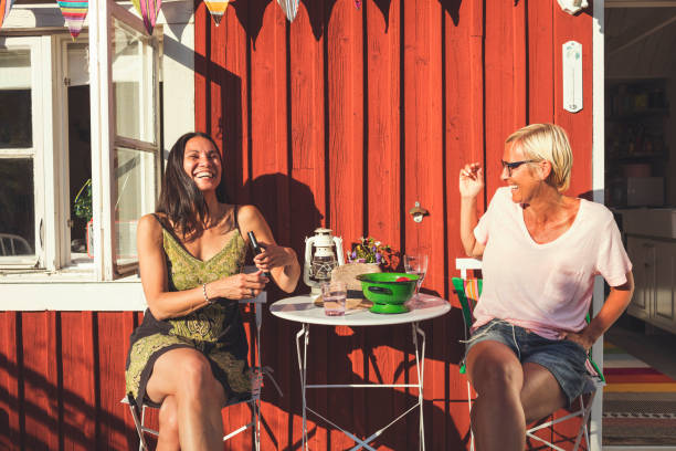 cheerful mature female friends enjoying summer in back yard on sunny day - garden decoration stock pictures, royalty-free photos & images