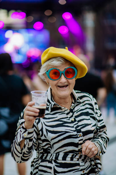 cheerful senior enjoying outdoor night concert in city. - concert stock pictures, royalty-free photos & images
