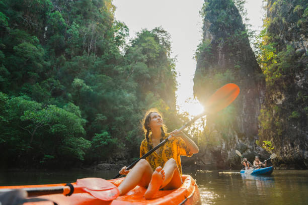 cheerful woman sea kayaking among karst formations and mangrove forest on krabi - travel stock pictures, royalty-free photos & images