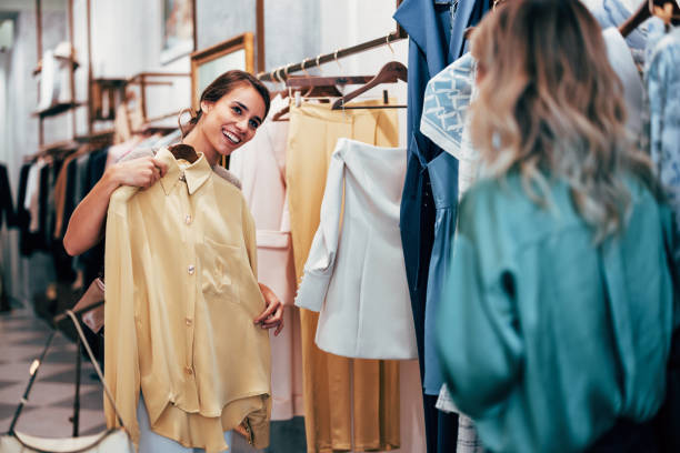 cheerful woman shopping for clothes in boutique store - fashion stock pictures, royalty-free photos & images