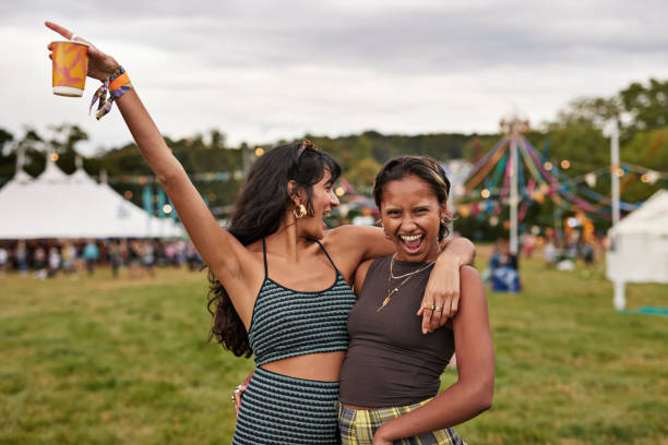 cheerful woman shouting while standing with female friend - concert stock pictures, royalty-free photos & images