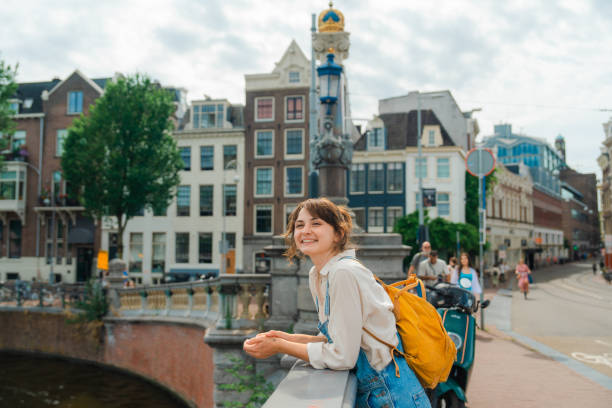 cheerful woman walking in amsterdam in summer - travel stock pictures, royalty-free photos & images