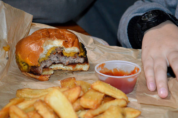 cheeseburger and french fries - junk food stock-fotos und bilder