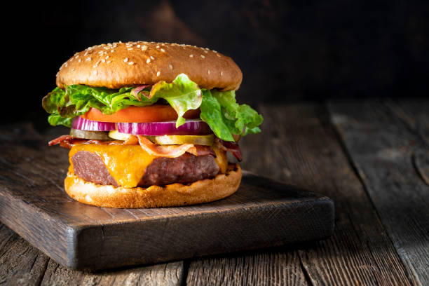 cheeseburger burger patty classic on rustic board of wood - junk food stock pictures, royalty-free photos & images