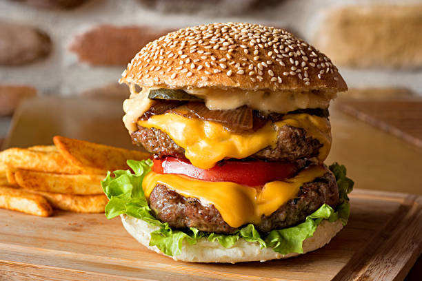 cheeseburger with french fries - junk food stockfoto's en -beelden
