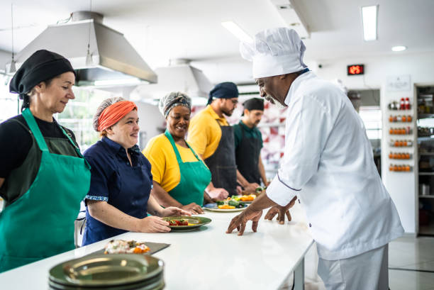 chef analyzing food prepared by students during cooking class - food stock pictures, royalty-free photos & images
