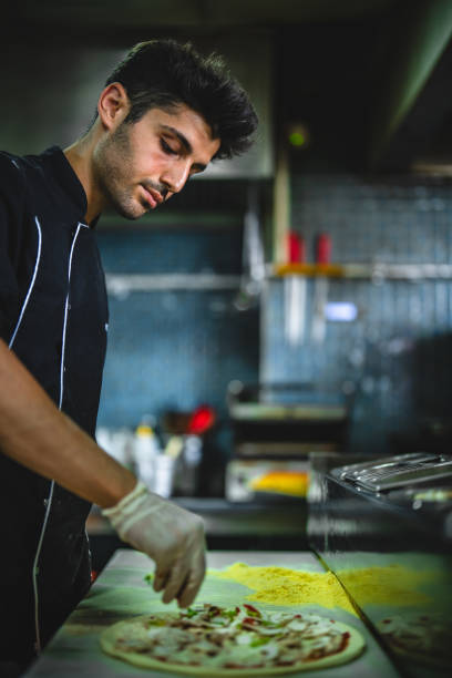 chef making pizza in restaurant kitchen - junk food stock pictures, royalty-free photos & images