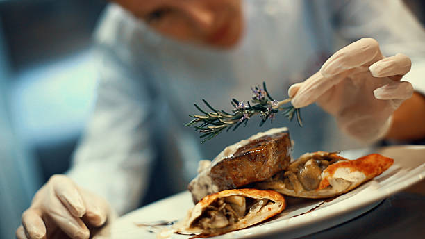 chef placing finishing touches on a meal. - food stock pictures, royalty-free photos & images