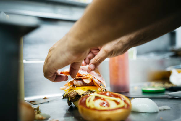 chef preparing a cheeseburger - junk food stock pictures, royalty-free photos & images