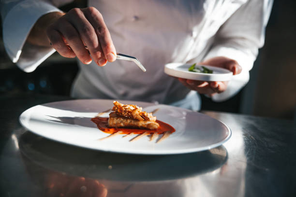 chef preparing a gilthead bream dish in a luxury restaurant - food stockfoto's en -beelden