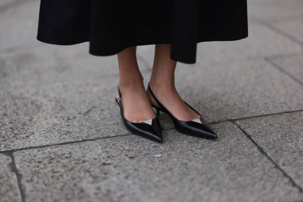 Cherifa Akili seen wearing Arket black oversized silk midi skirt and YSL black varnished leather ballet flats, during the Womenswear Fall/Winter...