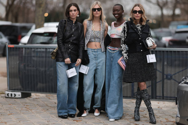 Chiara Baratello wears black skirt, vest, white bag & Linda Tol wears denim jeans, grey cropped top, vest & Erika Boldrin wears black jacket, denim...