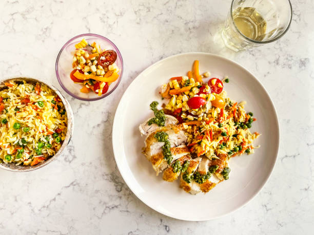 chicken breast, fried rice, and salad on a plate on white, marble background - food stock pictures, royalty-free photos & images