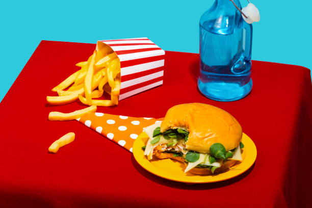 chicken burger and french fries with soda bottle on table against blue background - junk food stock pictures, royalty-free photos & images
